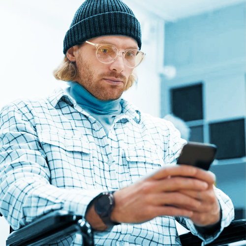 Man in a wheelchair looking at a smart phone