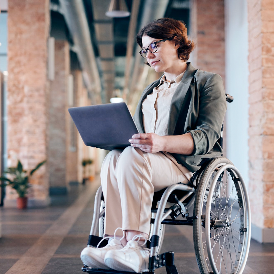 Woman sitting in a wheelchair looking at a computer